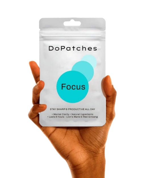 Hand holding a package of DoPatches Focus on a white background